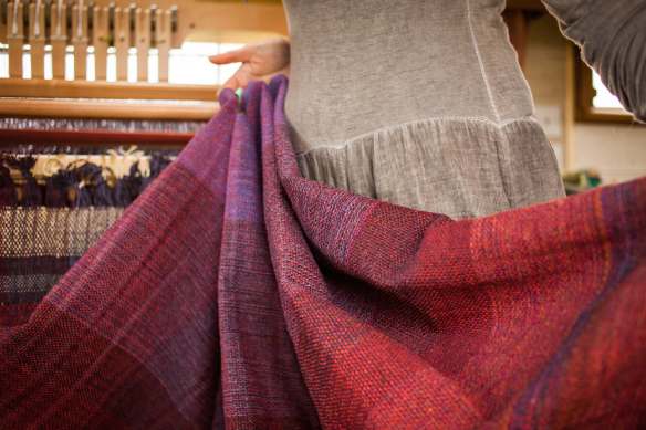 Rolling the waeving off the loom by Alice Carfrae